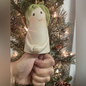 Thumb-shaped bell ornament with leaf-like hair